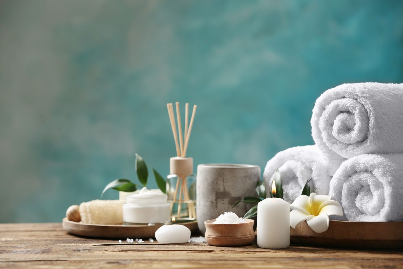 Salon & Spa Web Design Rolled spa towels, candles and aromatherapy oils on a wooden table
